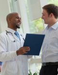 A medical professional holding a clipboard, consulting with a patient.